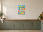 The Morning Has a Table — A2 artwork shown in a room with a natural wood frame; select a framed finish to include a frame