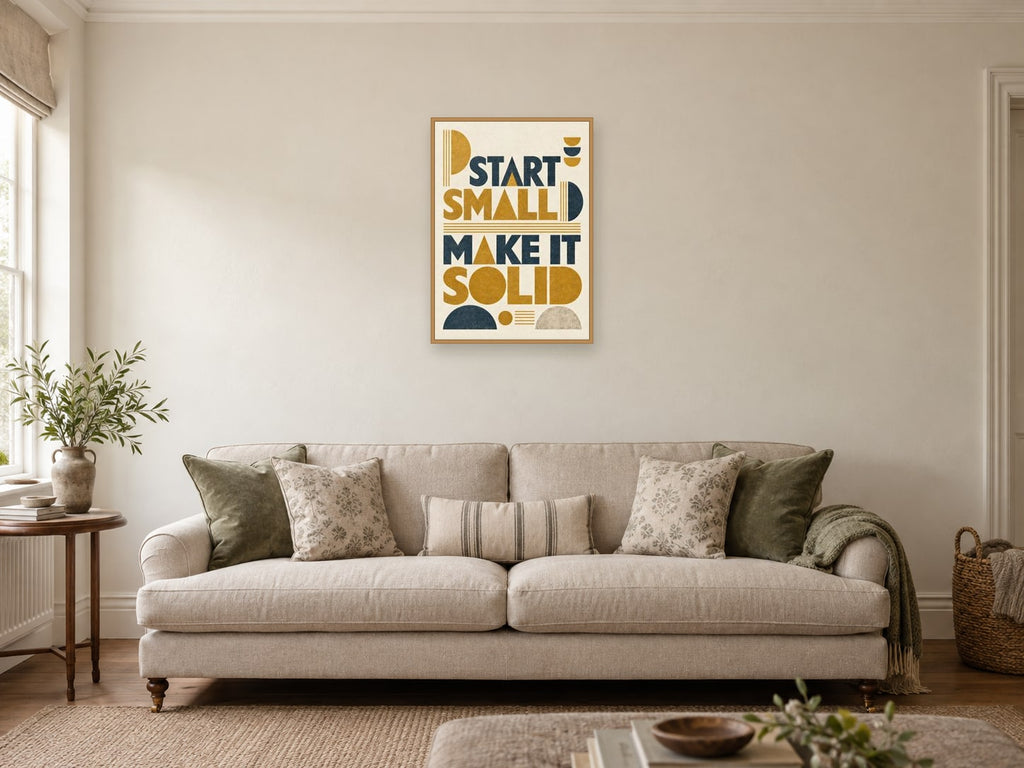 Start Small Make It Solid — A2 artwork shown in a room with a natural wood frame; select a framed finish to include a frame