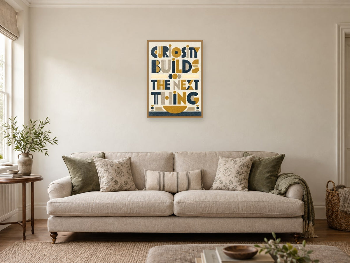 Curiosity Builds the Next Thing — A2 artwork shown in a room with a natural wood frame; select a framed finish to include a frame
