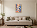 Scissors and Scraps — A2 artwork shown in a room with a natural wood frame; select a framed finish to include a frame