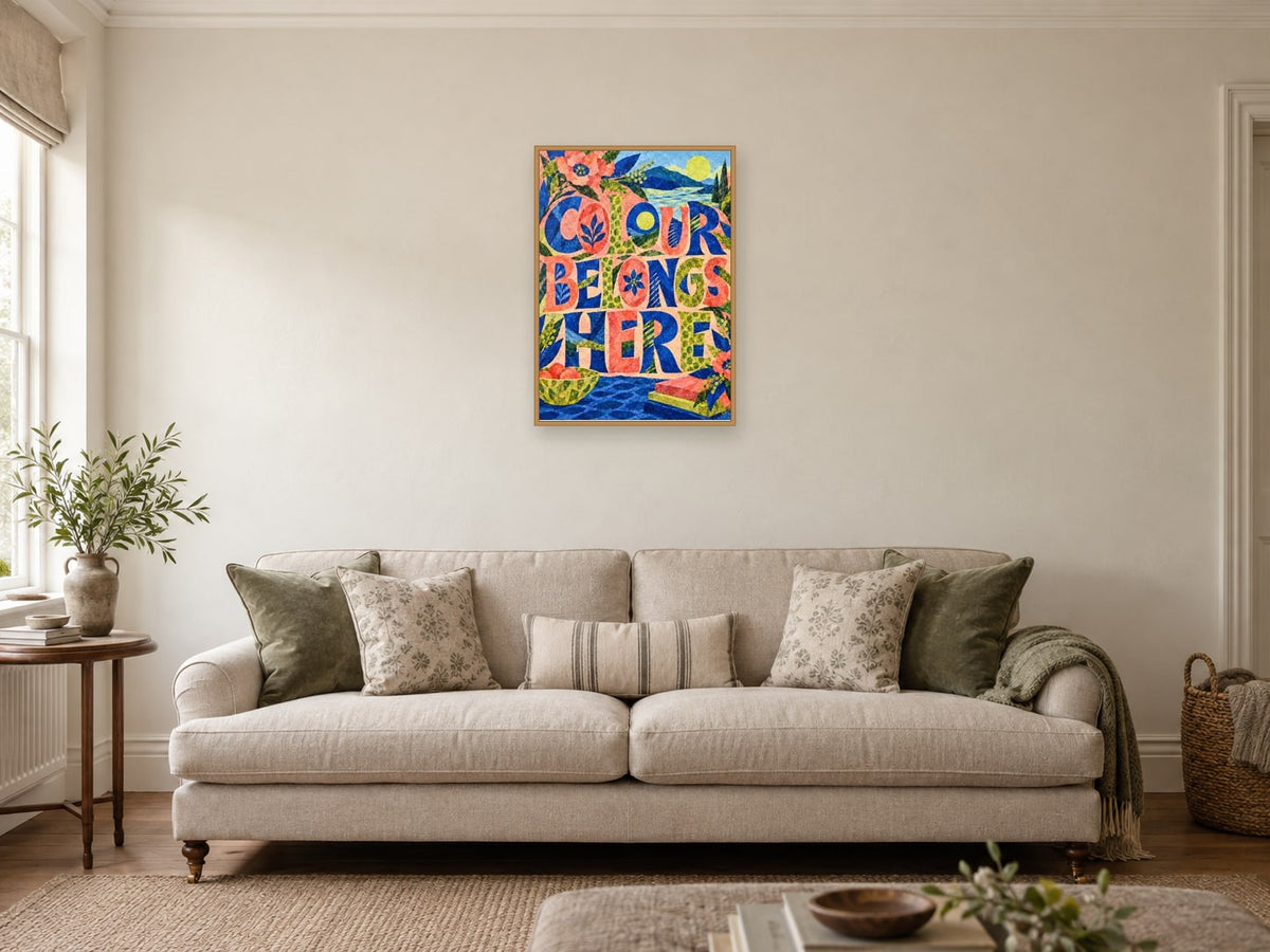 Colour Belongs Here — A2 artwork shown in a room with a natural wood frame; select a framed finish to include a frame