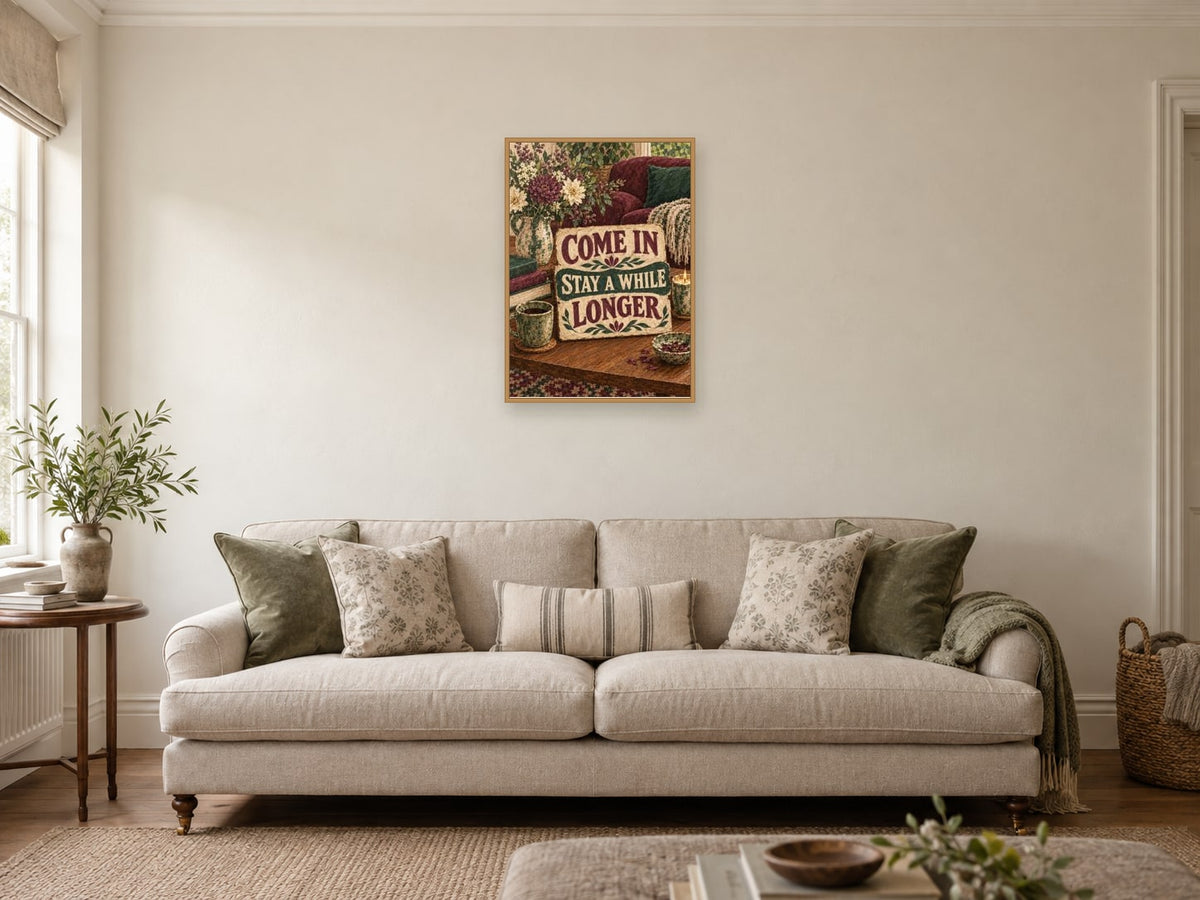 Come in Stay a While Longer — A2 artwork shown in a room with a natural wood frame; select a framed finish to include a frame