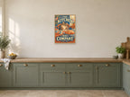 The Kitchen Has Company — A2 artwork shown in a room with a natural wood frame; select a framed finish to include a frame