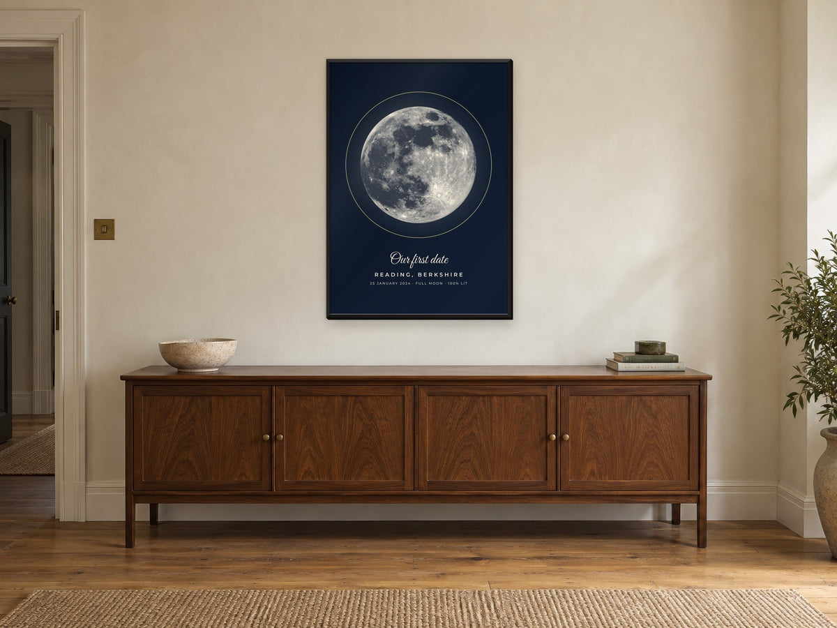 Moon phase poster of the full moon over Reading in the Midnight design, in a black frame, above a sideboard