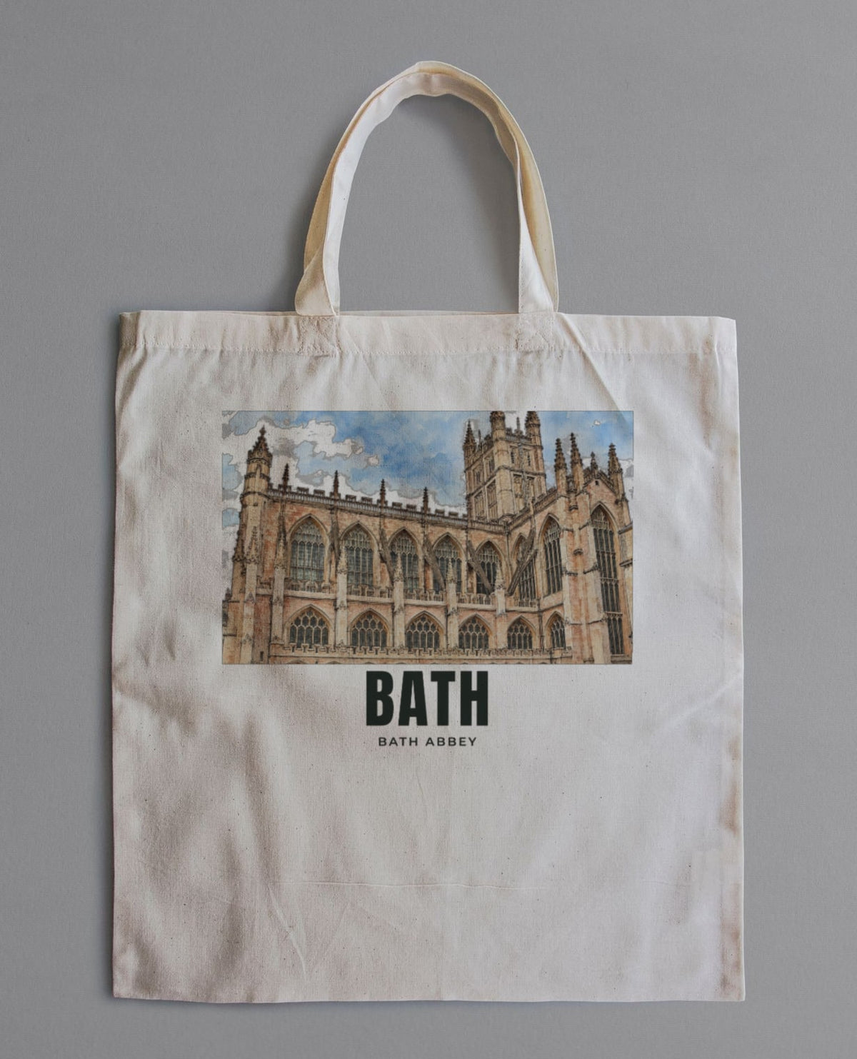 Personalised natural cotton tote bag laid flat, printed with a drawing of Bath Abbey and the name BATH